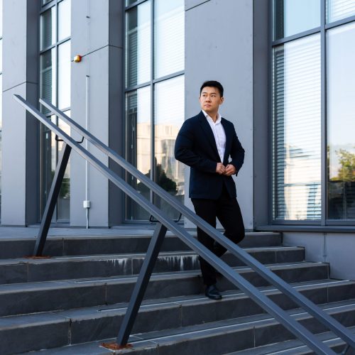 asian-businessman-walks-up-the-stairs-of-the-offic-2022-08-08-19-09-59-utc